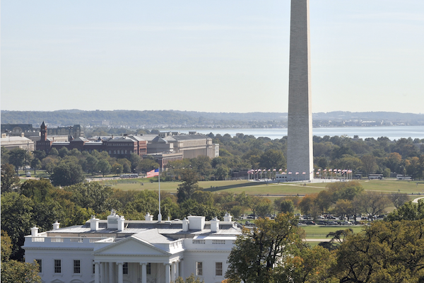 This image features the White House in the foreground with the Washington Monument in the background on a clear day.